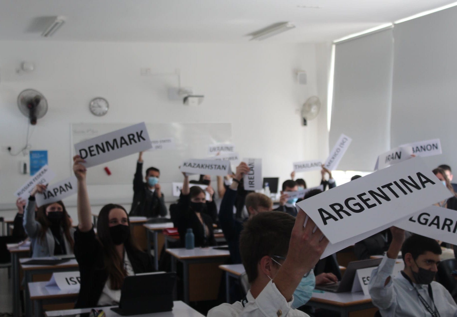 Delegates indoors lifting their placards